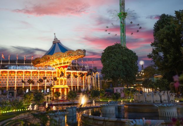 Tivoli Gardens in Copenhagen illuminated in the evening with colorful lights reflecting in the water. Photo: Nicolas Tobias Følsgaard