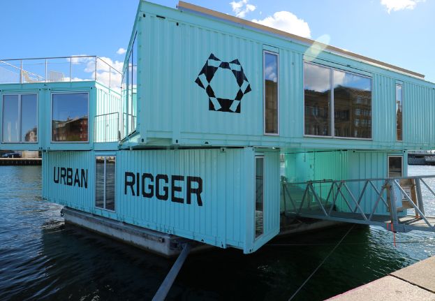 Floating turquoise Urban Rigger student housing made from shipping containers in Copenhagen’s harbor