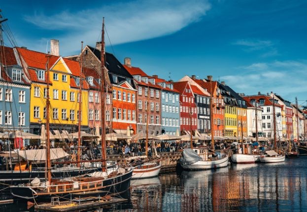 Farverige huse og træbåde set fra Nyhavnskanalen i København. eee