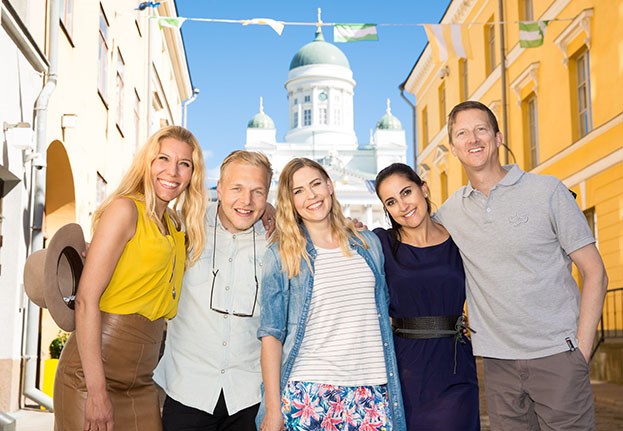 Group of smiling people posing together in front of the Helsinki Cathedral