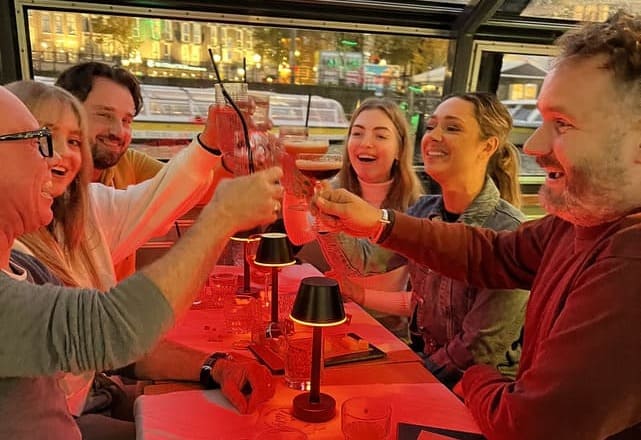 A group of people celebrating a good moment on a cocktail cruise